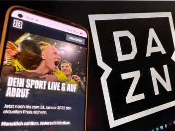 DAZN-Homepage auf einem Smartphone neben DAZN-Logo