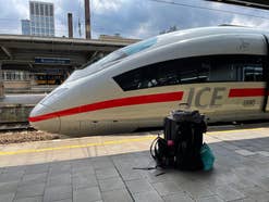 Ein ICE steht im Bahnhof - Koffer und Reisegepäck auf dem Bahnsteig davor