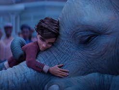 Der junge Peter umarmt einen magischen Elefanten.