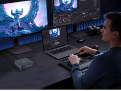 Ein Mann sitzt vor mehreren Bildschirmen und bearbeitet ein Bild