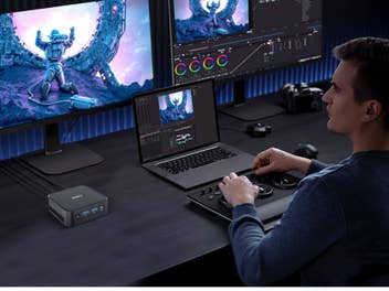 Ein Mann sitzt vor mehreren Bildschirmen und bearbeitet ein Bild