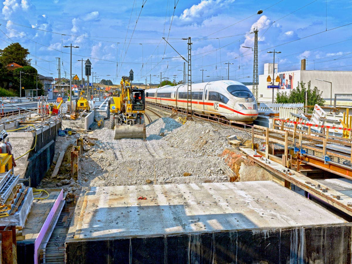 Baustelle am Bahnhof Rottendorf mit durchfahrendem ICE.