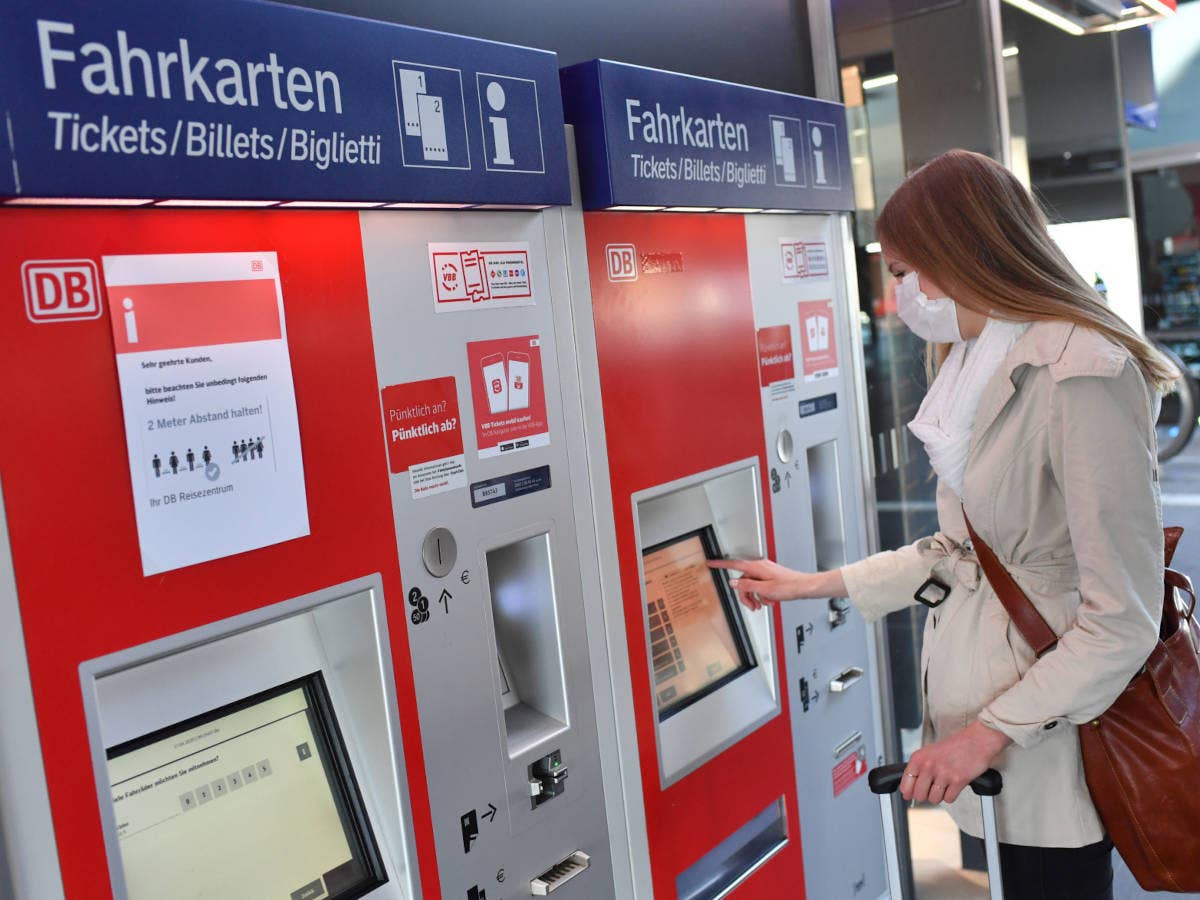 Frau kauft Fahrschein an einem Ticketautomaten der Deutschen Bahn