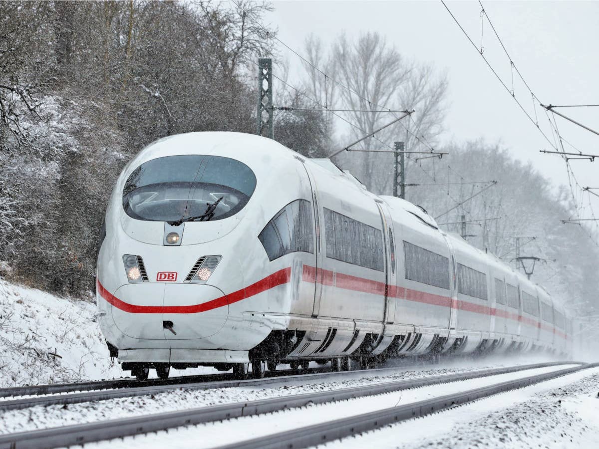 Ein ICE der Deutschen Bahn fährt durch eine Winterlandschaft.