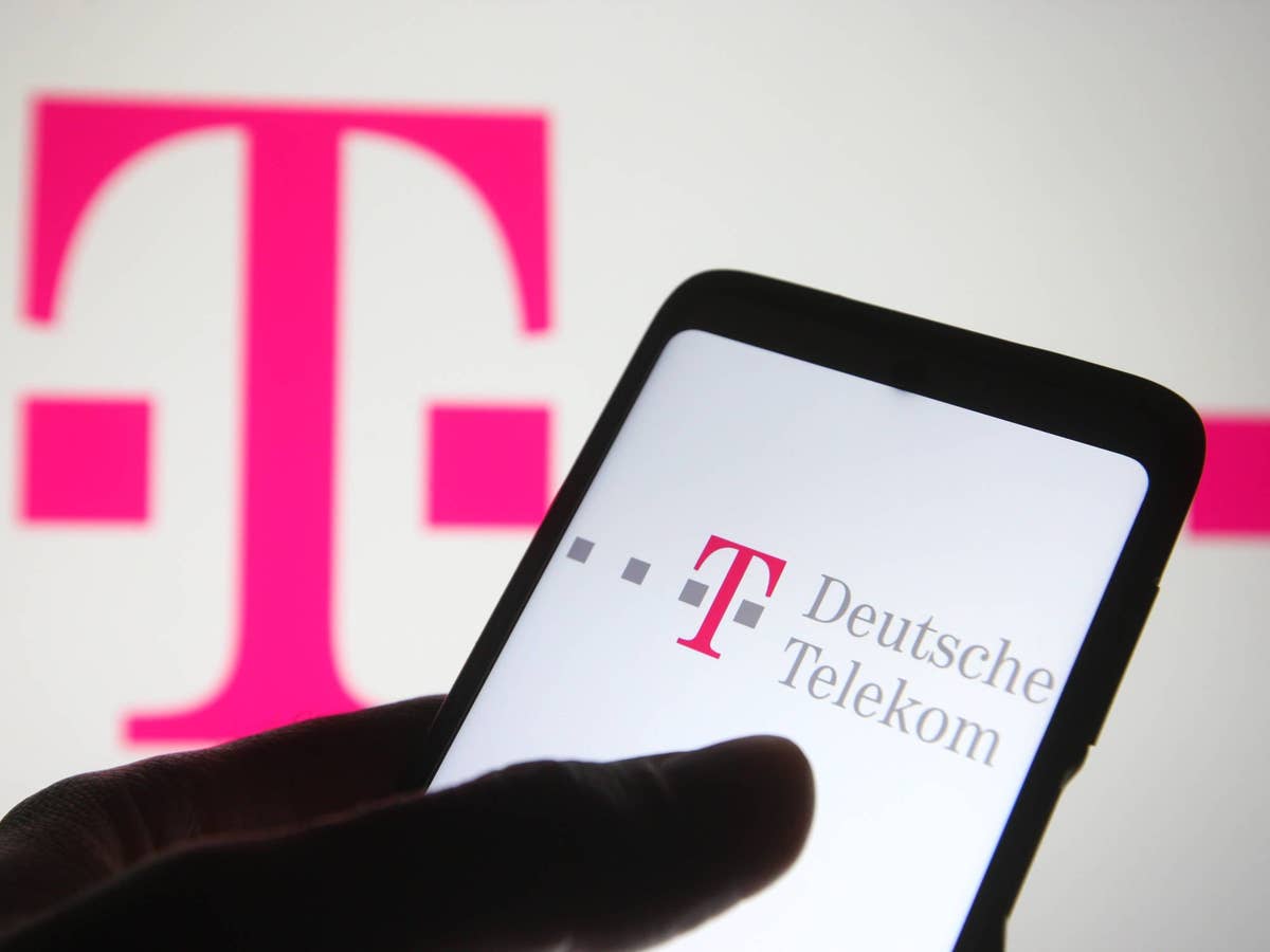 Das Telekom-Logo im Hintergrund - im Vordergrund ist ein Smartphone zu sehen