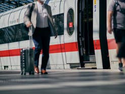 Reisende auf dem Bahnsteig im Hauptbahnhof Berlin vor ICE