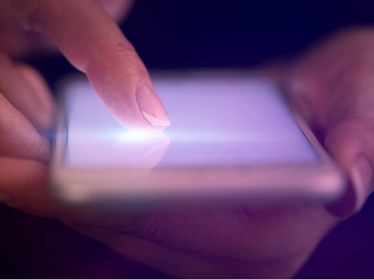 Frau bedient mit ihrem Zeigefinger ein Smartphone-Display.