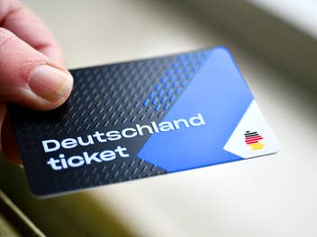 Hand hält Deutschlandticket