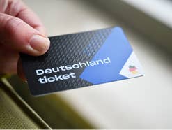 Deutschlandticket in der Hand gehalten.