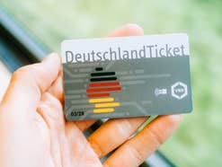 Deutschlandticket in der Hand eines Mannes.