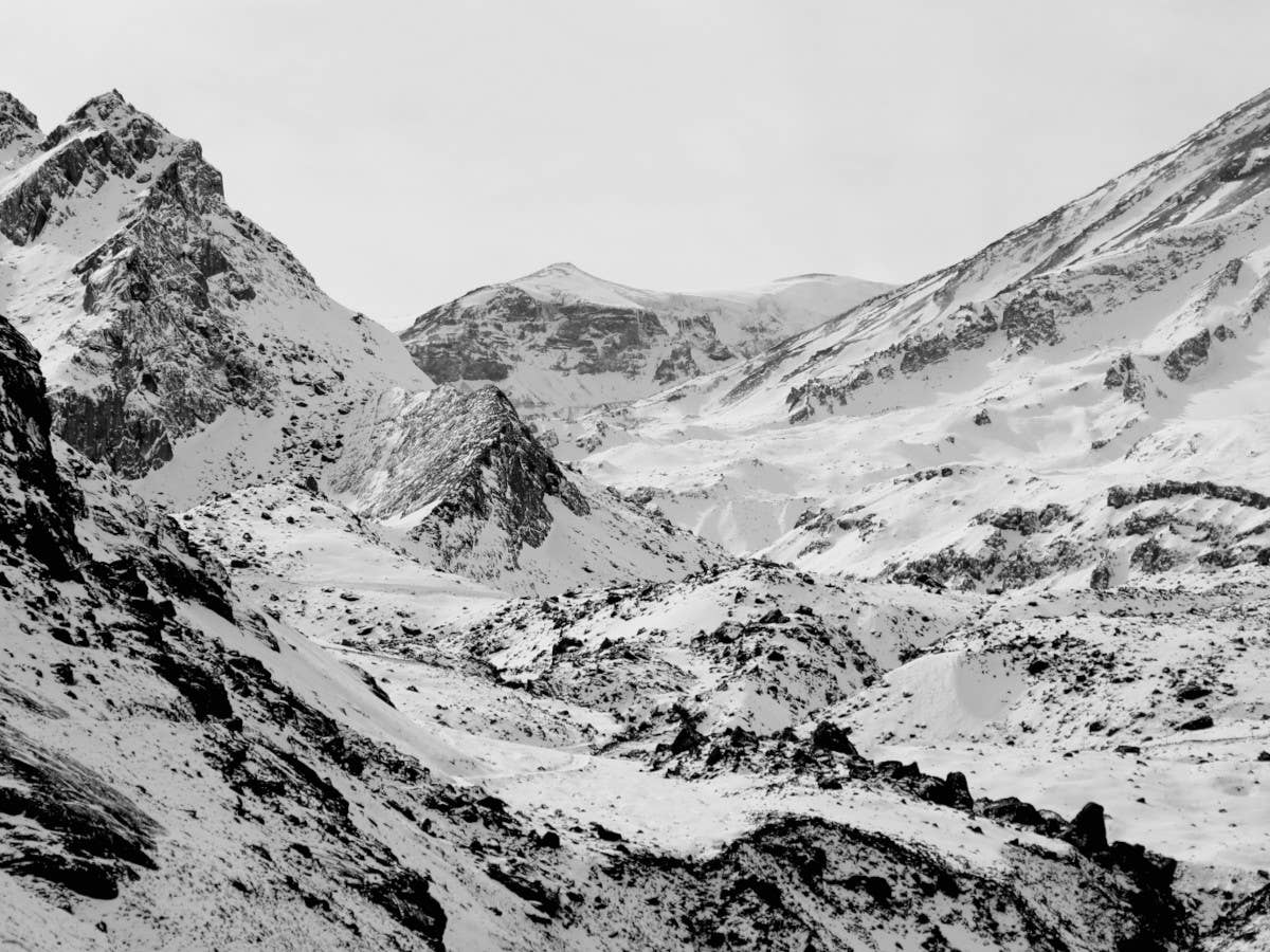 Die Schneegesellschaft Schwarz-Weiß-Bild von schneebedeckten Berggipfeln.