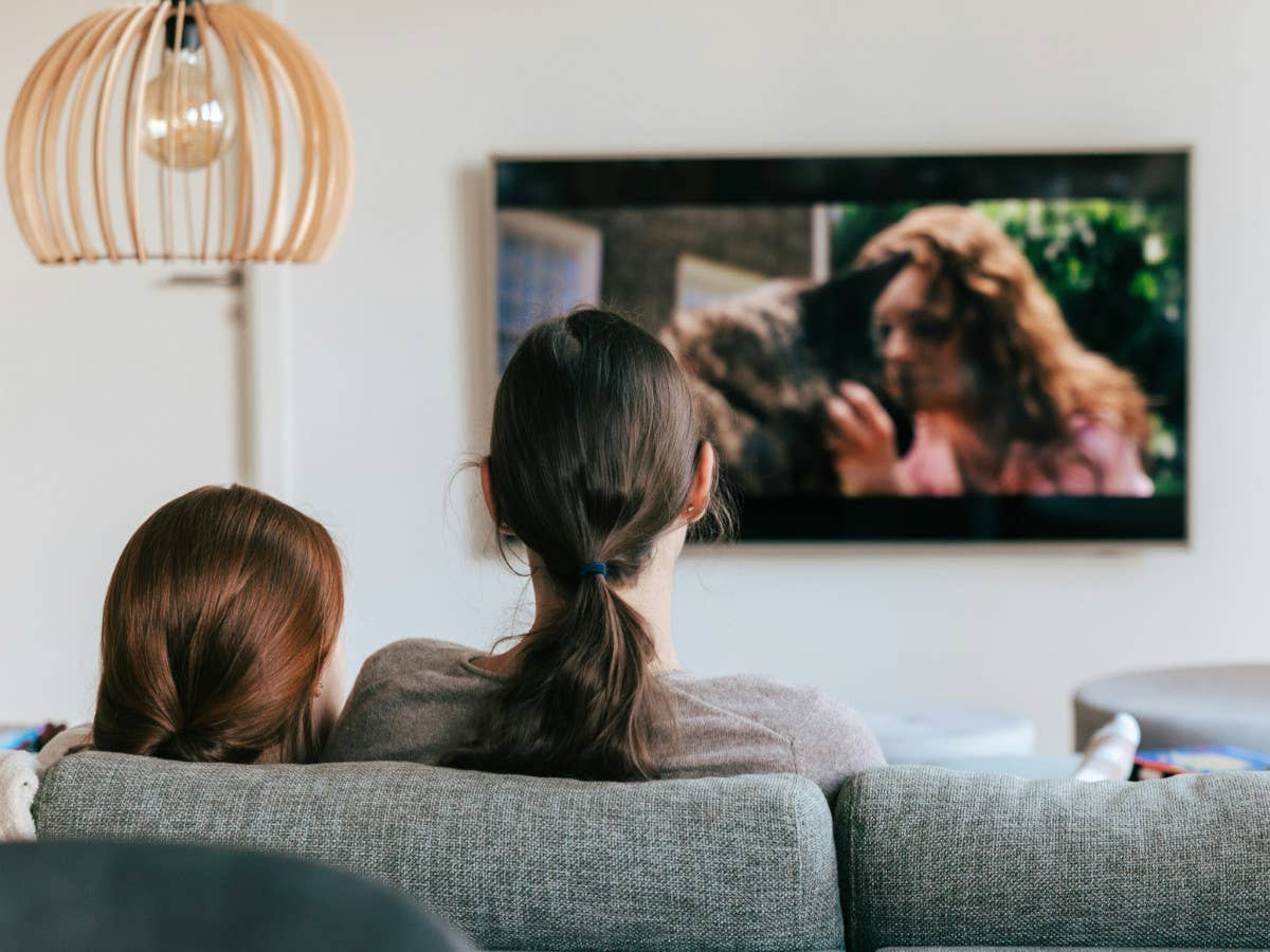 Zwei Frauen sitzen auf dem Sofa und gucken TV