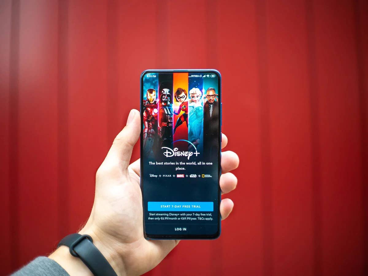Disney+ auf einem Handy vor rotem Hintergrund