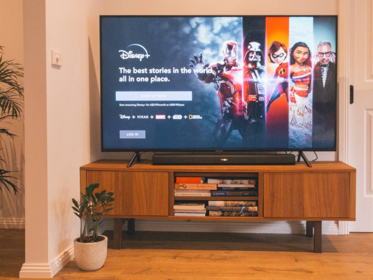 Disney+ auf einem TV Disney+ auf einem Fernseher, der auf einer hölzernen Kommode steht.