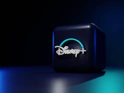 Das Disney+ Logo auf einem Würfel vor blauem Hintergrund