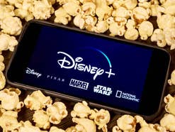 Das Disney+-Logo auf einem Smartphone, das in Popcorn liegt