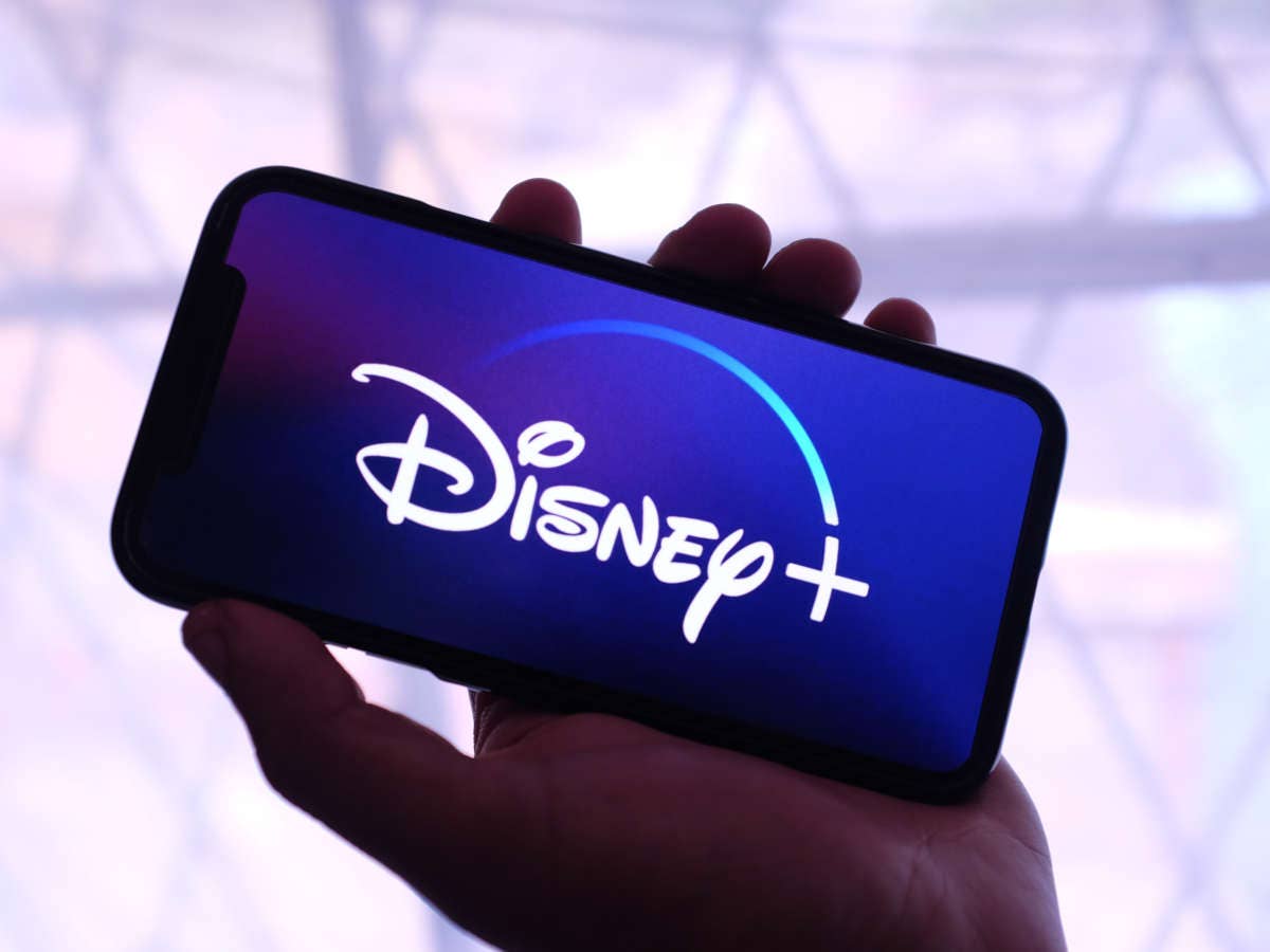 Smartphone in einer Hand mit Disney+ Logo im Display