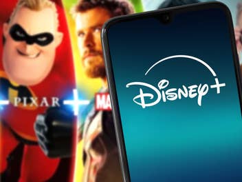 Disney+ auf einem Handy dahinter einige Shows des Anbieters