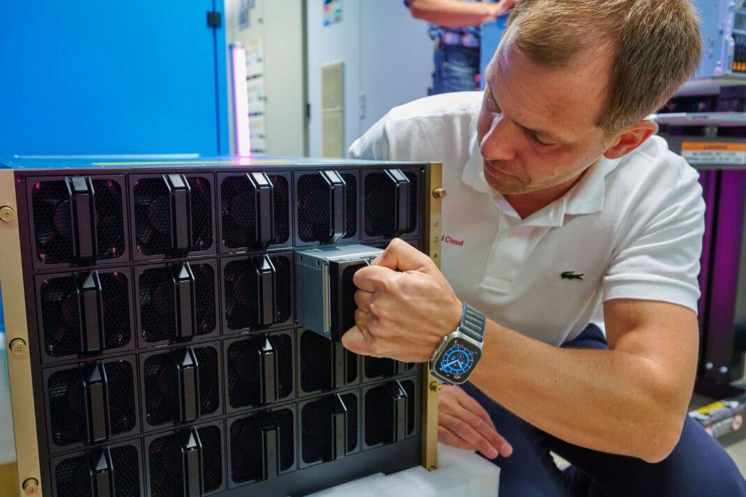 Christian Kotulek, Senior Product Manager Industrial AI Cloud zieht einen Lüfter aus der GPU.