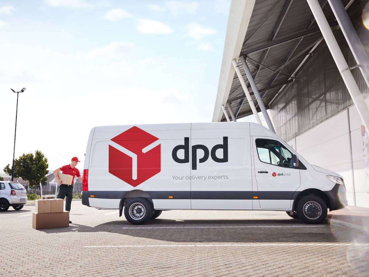 DPD-Paketbote packt Pakete in seinen Lieferwagen.