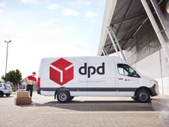 DPD-Paketbote packt Pakete in seinen Lieferwagen.