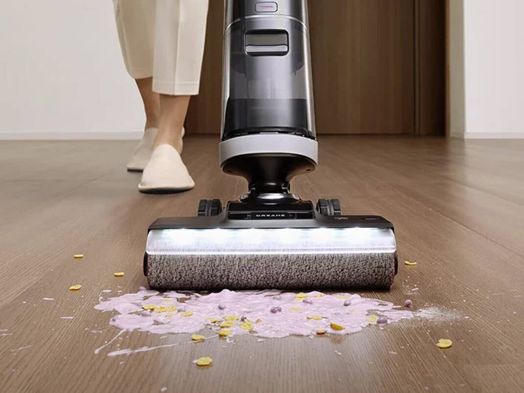 Ein Saugwischer wischt einen Fleck von einem Holzboden auf