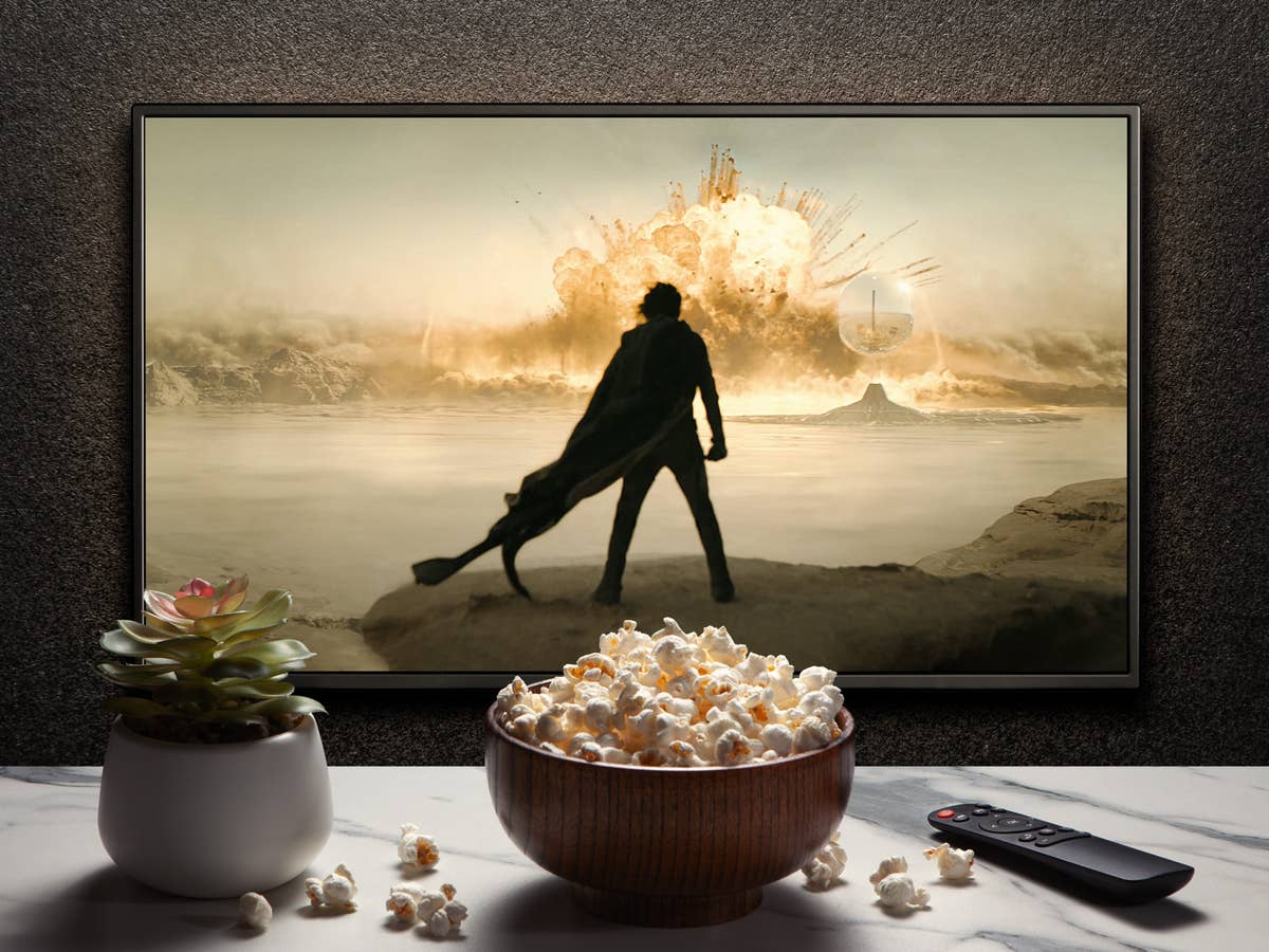 Dieser Film sorgt schon Monate vor Kino-Start für ausverkaufte Säle. Bildschirm zeigt dunkle Figur in der Wüste vor einer Explosion, davor ein Tisch mit Pflanze, Popcorn und Fernbediehnung