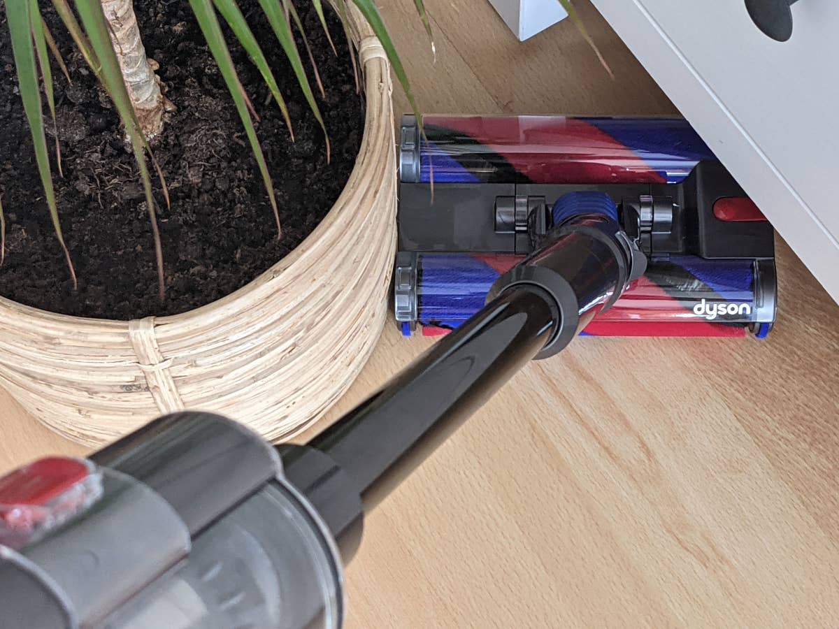 Der Dyson Omni-glide Akku-Staubsauger zwischen Schrank und einer Pflanze