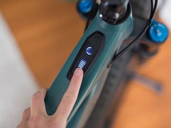 Ein Finger zeigt auf die Akku-Status-Anzeige eines E-Bikes