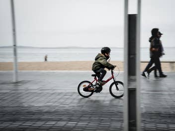 Ein Kind auf einem Fahrrad fährt auf einem Boulevard.