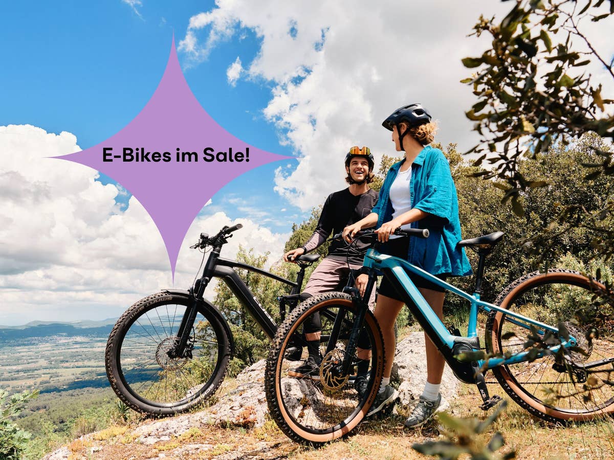 Zwei Personen stehen mit E-Bikes in der Natur