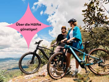 Zwei Personen stehen mit E-Bikes auf einem Weg