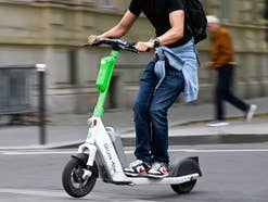 Mann fährt auf einem E-Scooter.