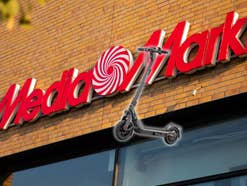 E-Scooter vor einem MediaMarkt-Logo
