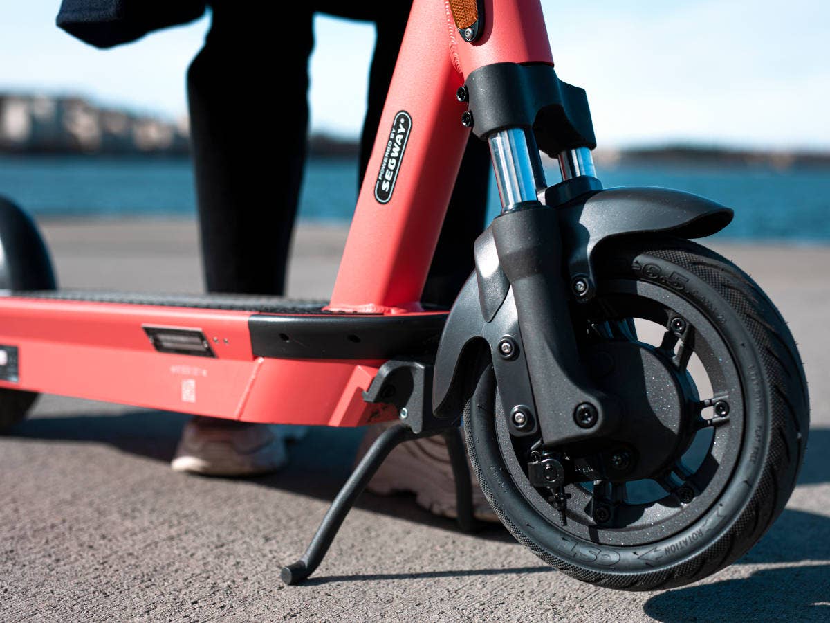 E-Scooter Nahaufnahme des Vorderrades vor einem Gewässer