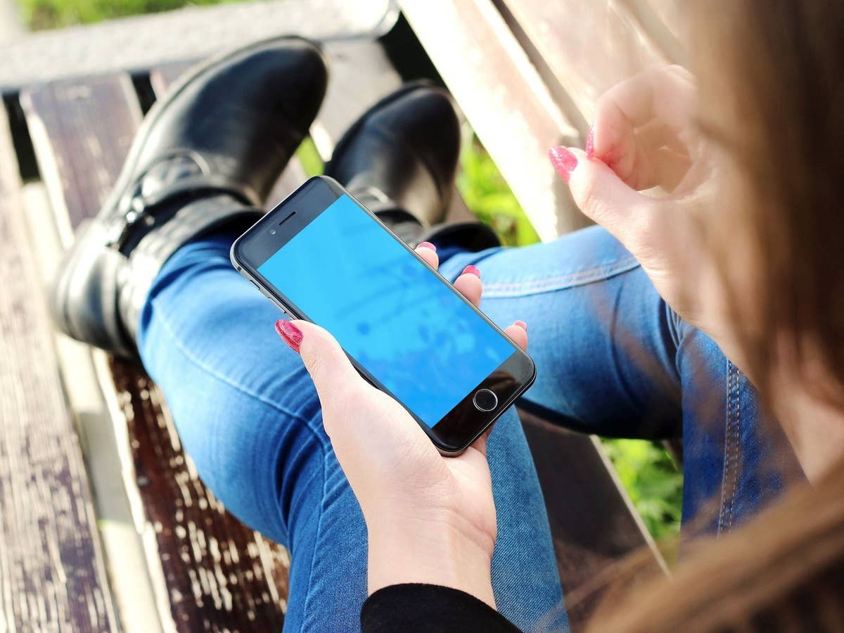 Eine Frau hält ein iPhone in der Hand