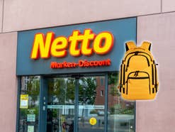 Eingang eines Netto-Geschäfts daneben ein Notfallrucksack