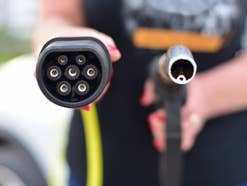 Elektroauto gegen Diesel: Der verblüffende Sieger Elektro-Ladekabel neben Kraftstoffdüse.