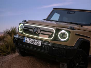 Mercedes-Benz G580 mit EQ-Technologie in der Frontansicht mit eingeschaltetem Licht.