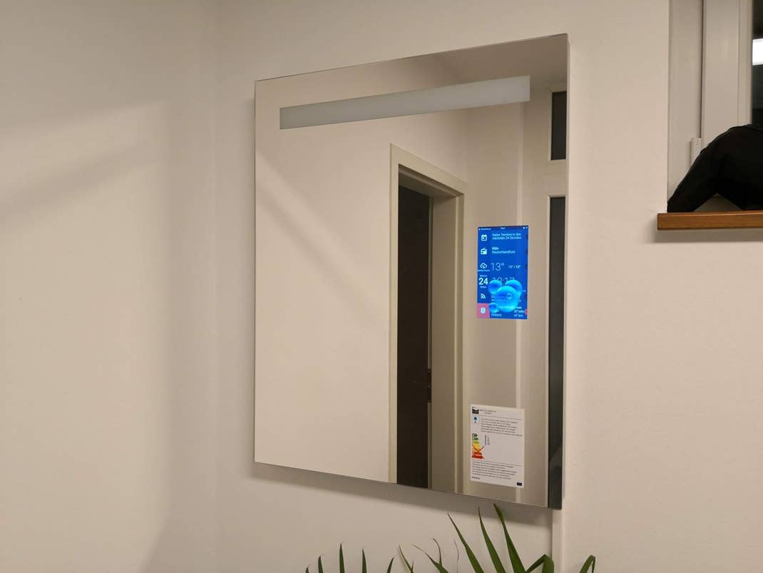 Ein Wandspiegel mit einem eingebauten kleinen Display