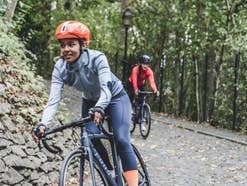 Menschen fahren mit E-Bikes in einem bewaldeten Gebiet.