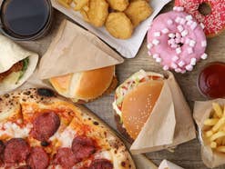 unterschiedliches Fast-Food von Donuts über Pizza, Burger und Pommes