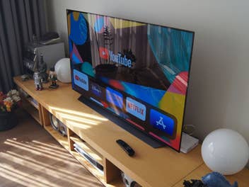Ein Fernseher steht in einem Wohnzimmer und spiegelt