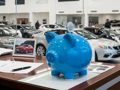 Sparschwein steht auf einem Tisch in einem Autohaus.