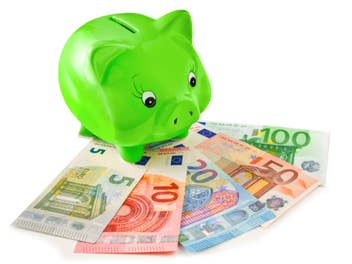 Grünes Sparschwein steht auf Euro-Banknoten.