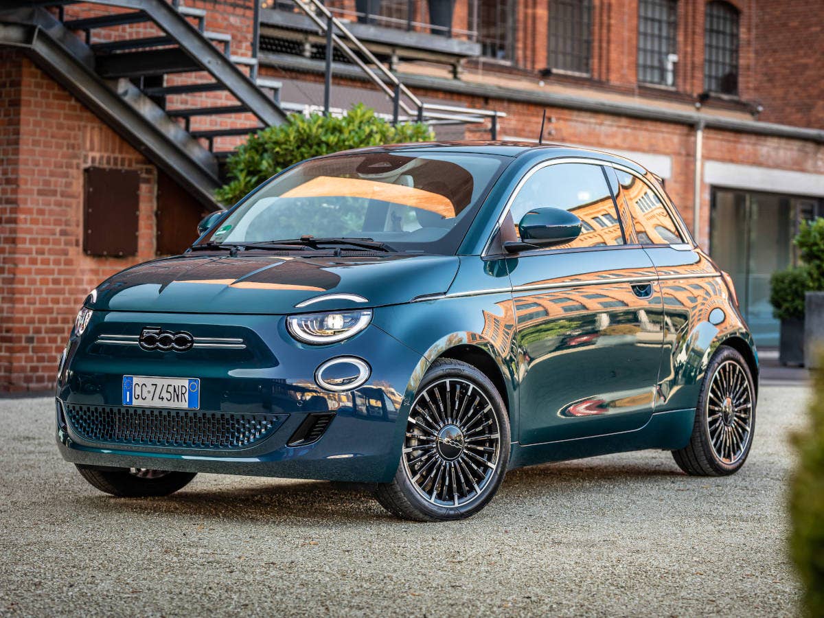 Fiat 500e in der Front-Seitenansicht vor einem Gebäude in Italien.