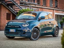 Fiat 500e in der Front-Seitenansicht vor einem Gebäude in Italien.