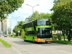 FlixBus fährt in München über Straße mit Bäumen
