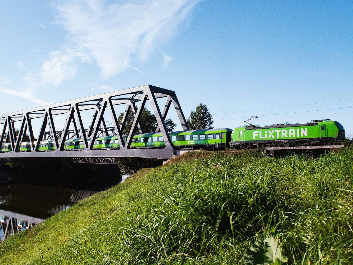 Flixtrain fährt über eine Brücke.