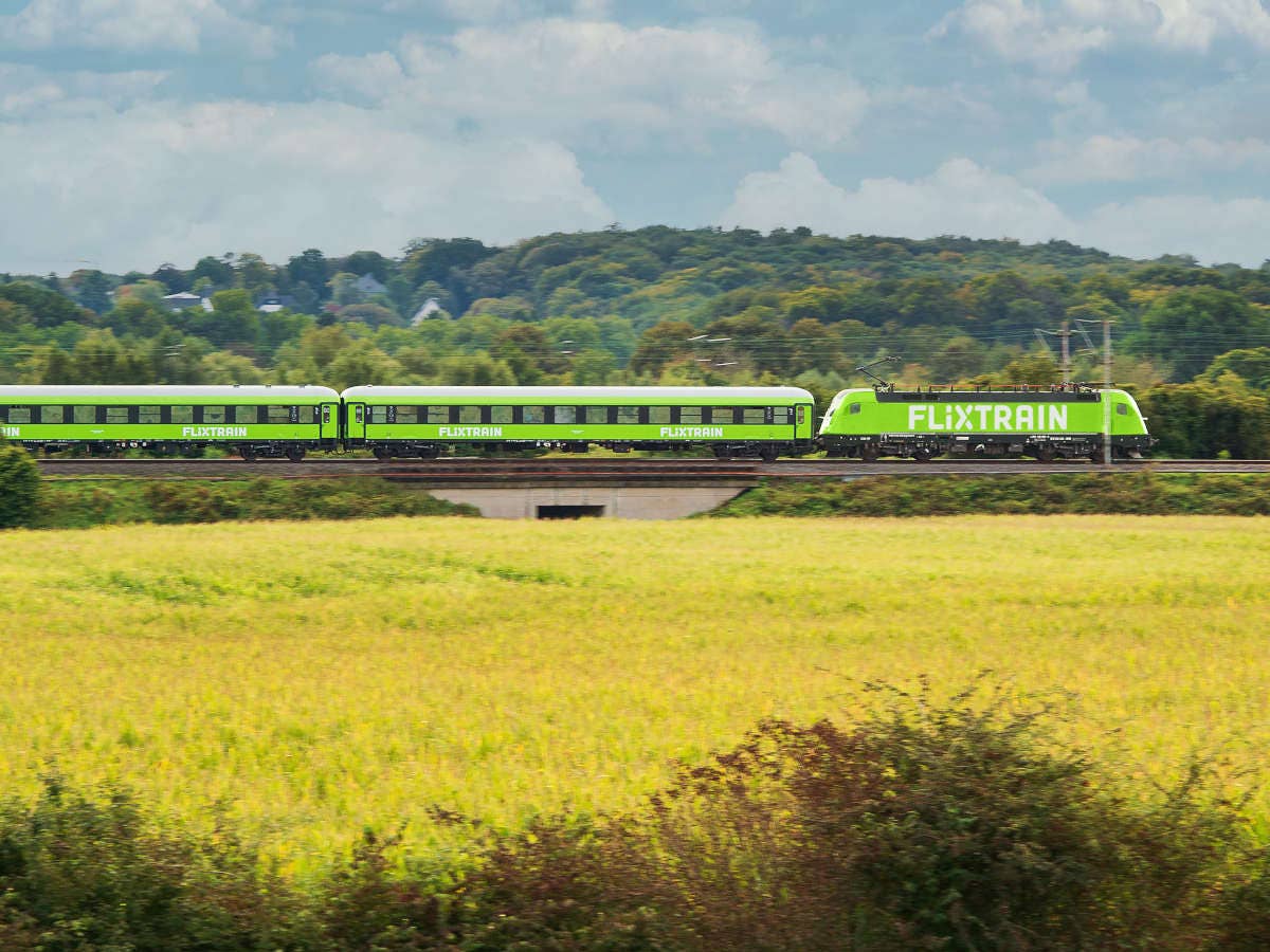 FlixTrain in der Seitenansicht vor einem Feld.